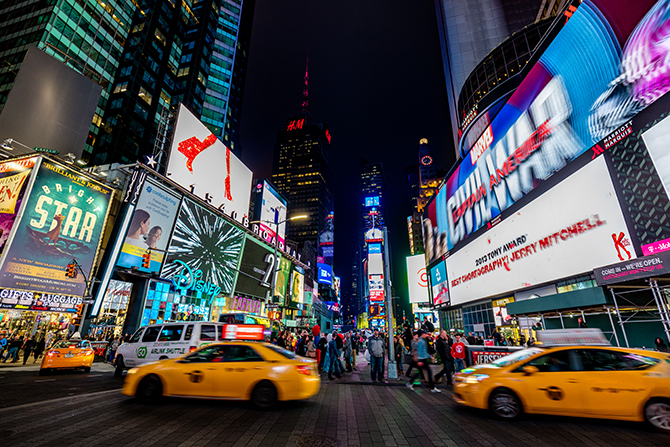 Crowded Times Square full of people and driving yellow cabs. Long exposure. Manhattan, New York City, USA.